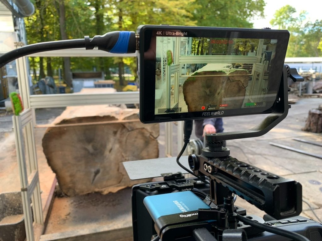 Monitor zeigt das Zuschneiden eines Holzstamms